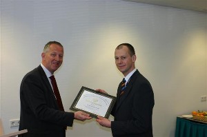 Cmdr. Willem Voogt, RNLN (l), presents a certificate of apprecation to guest speaker Gilbert Overmaat for his February speech on the Defense Security and Safety division of the Netherlands Organization for Applied Scientific Research (TNO DSS).
